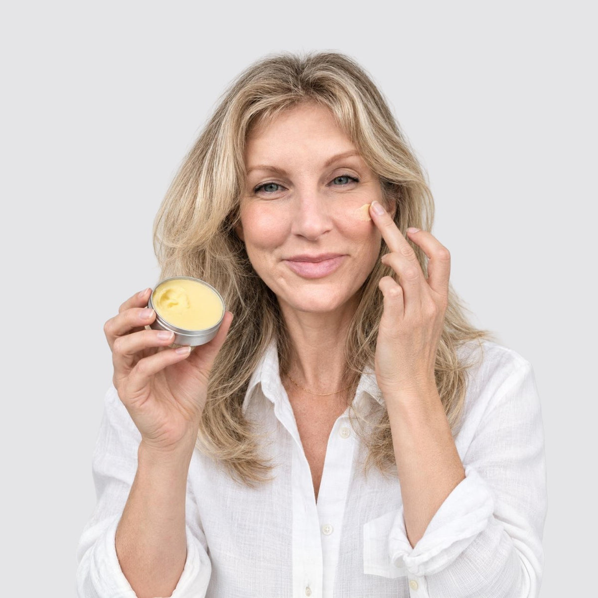 Woman applying eekoHome Tallow Balm to her cheek