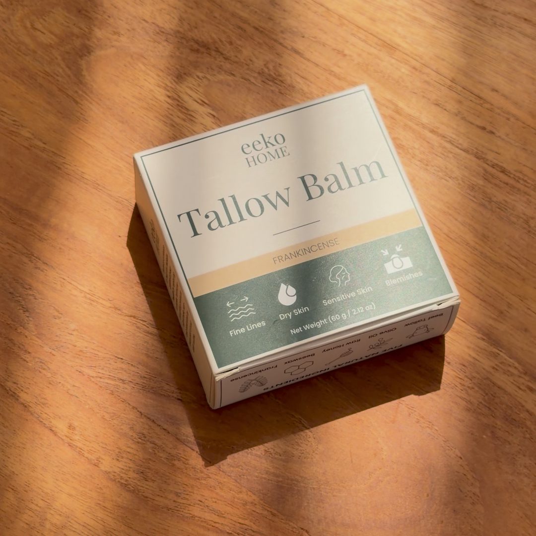 eekoHome Tallow Balm box on a wooden table in streaming sunlight